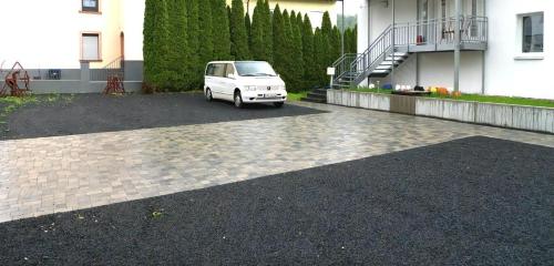 a white van parked in a parking lot next to a building at Perle Lollipop in Bullay