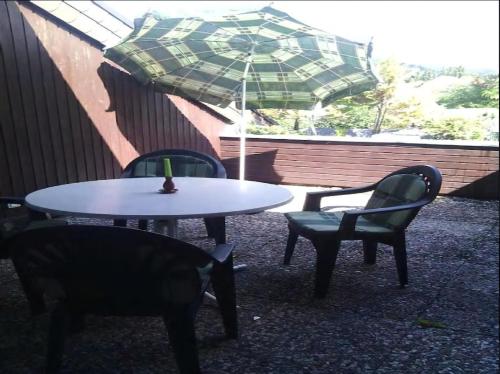 a table and chairs and an umbrella on a patio at Paradies Hoffmann in Bad Lauterberg