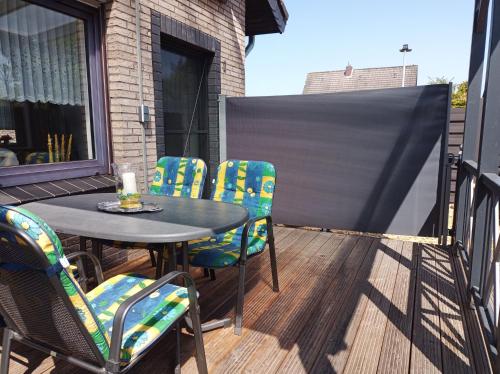 a patio with a table and chairs on a balcony at Ferienwohnung Zwei Finken In Wiesmoor in Wiesmoor