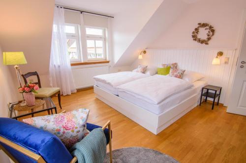 a bedroom with a large white bed and a chair at Gemütliche Wohnung In Bracht Mit Terrasse Und Garten in Rauschenberg