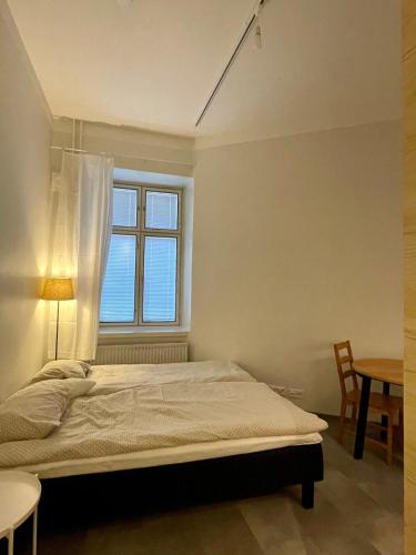 a bedroom with a bed and a window at Töölö Sleephouse in Helsinki
