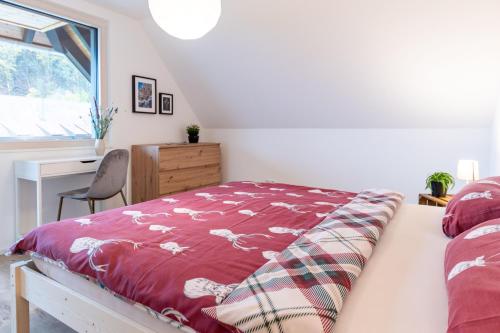 a bedroom with a bed with a red blanket at Fewo Mit Whirlpool Und Fass Sauna Im Schwarzwald in Hausach