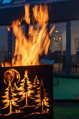 a fire pit in a living room with flames at Fewo Mit Whirlpool Und Fass Sauna Im Schwarzwald in Hausach
