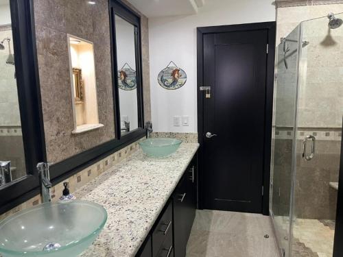 a bathroom with two sinks and a glass shower at Casa Perrine at Linda Vista 2-412 in Las Conchas
