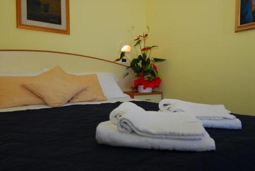a bedroom with two towels on a bed at Hotel Ambasciata in Cesenatico