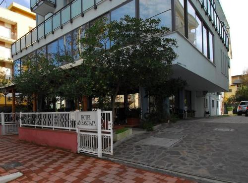 a white fence in front of a building at Hotel Ambasciata in Cesenatico
