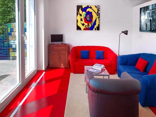 a living room with red and blue couches at Lollipop in Bullay