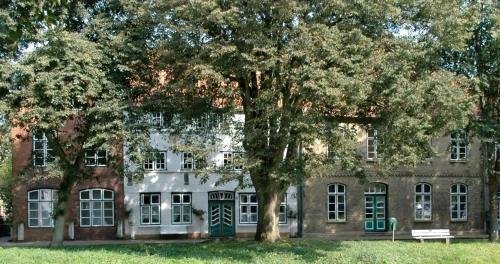 a large brick building with a tree in front of it at Ferienwohnung In Friedrichstadt Mit Garten in Friedrichstadt