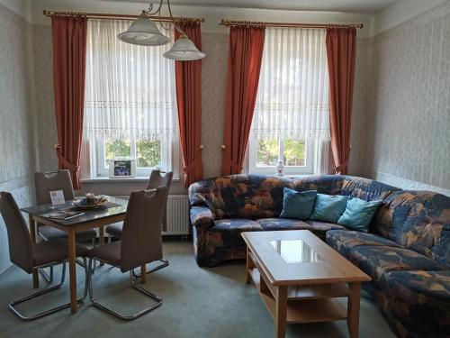 a living room with a couch and a table at Villa An Der Wetterstation in Tabarz