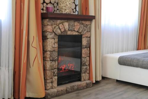 a stone fireplace in a room with a bed at Modernes Ferienhaus In Daun in Daun