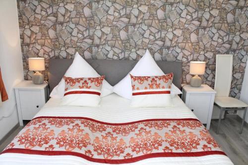 a bedroom with a large bed with a stone wall at Modernes Ferienhaus In Daun in Daun