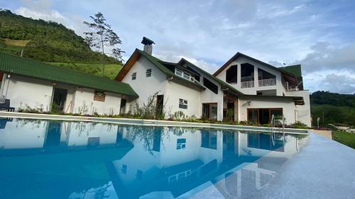 a house with a swimming pool in front of it at Göttlich Boutique Hotel in Pozuzo