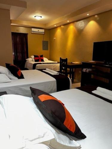 a hotel room with three beds and a television at Hotel San Sebastian in Gracias