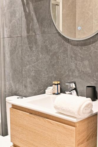 une salle de bain avec un lavabo et un miroir dans l'établissement Studio Raffiné près de la Seine Paris 16ème, à Paris