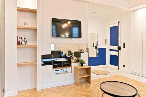 ein Wohnzimmer mit Sofa und Tisch in der Unterkunft Studio Raffiné près de la Seine Paris 16ème in Paris