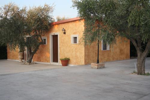 a yellow building with trees and a courtyard at da Biagio B&B - Ristorante in San Severo