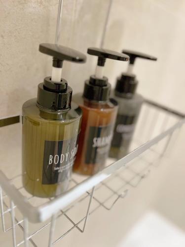 three bottles of soap sitting on a shelf at L'Ecrin de Chablis - Appartement avec cour privée in Chablis