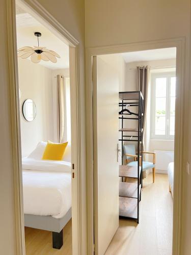 a bedroom with a bed and a room with a ladder at L'Ecrin de Chablis - Appartement avec cour privée in Chablis