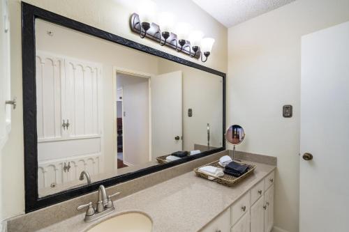 a bathroom with a sink and a large mirror at Spacious 4BR with Private Pool, Near Six Flags in San Antonio