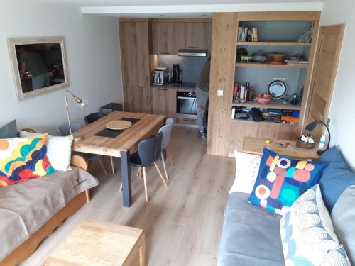 a living room with a table and a couch at Le Soladret - 2 pièces 4 étoiles - Vue extraordinaire sur les Aravis in La Clusaz