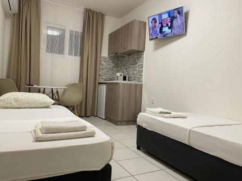 a hotel room with two beds and a kitchen at Sunny Beach Potos in Potos