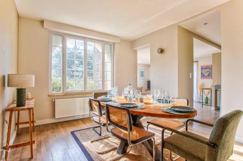 une salle à manger avec une table et des chaises dans l'établissement Villa Garcane à 200 m de la mer - Cabourg, à Varaville