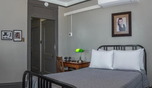 a bedroom with a bed and a table with a lamp at Gardner Hotel & Hostel in El Paso