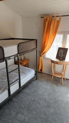 une chambre avec deux lits superposés et une table dans l'établissement La Chouette Maison, à Florensac