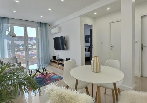 un salon avec une table et des chaises blanches dans l'établissement Mike by Terry's Homes, à Cannes