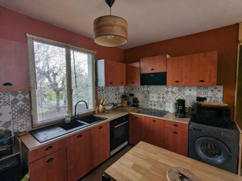 La cuisine est équipée de placards en bois, d'un évier et d'un lave-vaisselle. dans l'établissement Gite L'Instant d'Aubrac, à Soulages-Bonneval