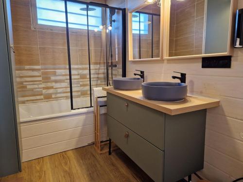 une salle de bain avec deux lavabos et une fenêtre dans l'établissement Gite L'Instant d'Aubrac, à Soulages-Bonneval