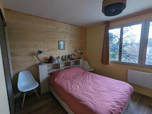 une chambre avec un lit, une chaise et une fenêtre dans l'établissement Gite L'Instant d'Aubrac, à Soulages-Bonneval