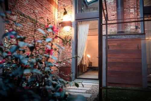 un edificio de ladrillo con una puerta y un árbol en Loft Tabaccaia 13, en Piantravigne