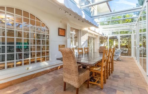 a conservatory dining room with a wooden table and chairs at Stunning Home In El Campello in El Campello