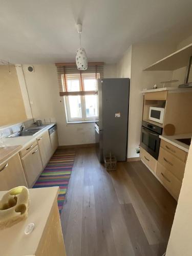 une cuisine vide avec un réfrigérateur et une fenêtre dans l'établissement La Lutine, à Luc-sur-Mer