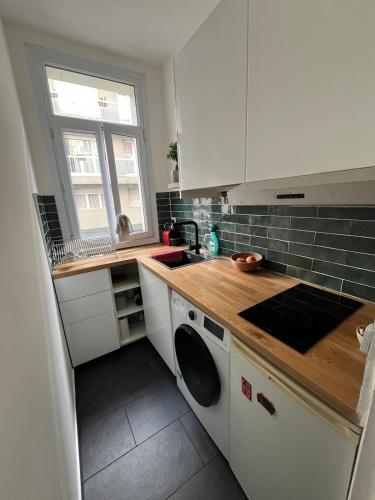 une cuisine avec un évier et une machine à laver dans l'établissement Charming flat at the heart of Paris, à Paris