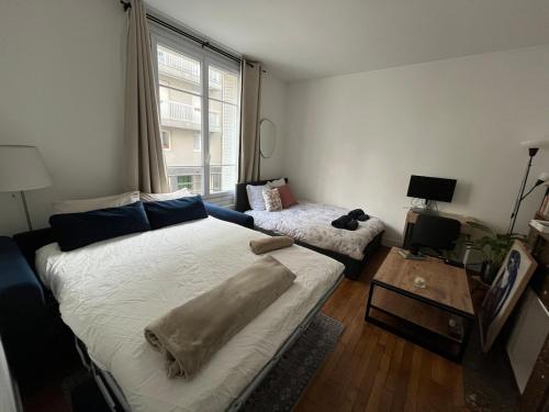 une chambre avec un grand lit et une table dans l'établissement Charming flat at the heart of Paris, à Paris