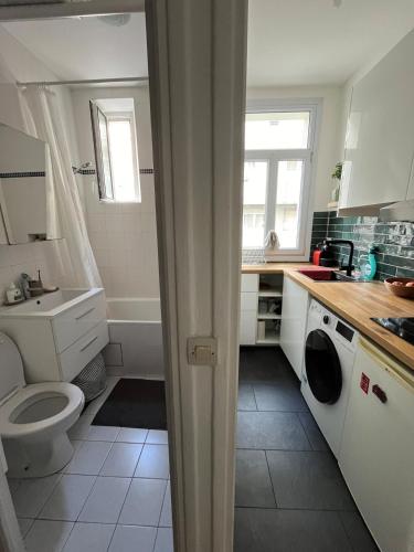 une salle de bain blanche avec des toilettes et un lavabo dans l'établissement Charming flat at the heart of Paris, à Paris