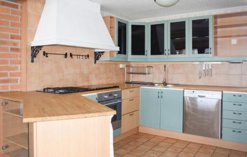 a kitchen with blue cabinets and a white hood at Awesome Home In Lekeryd With Wifi in Lekeryd