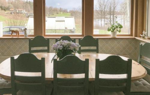 a dining room table with chairs and a vase of flowers at Awesome Home In Lekeryd With Wifi in Lekeryd
