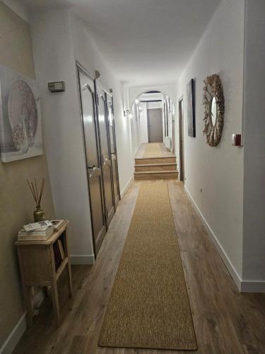 a hallway with white walls and a hallway with a carpet at La Passiflore in Vergèze