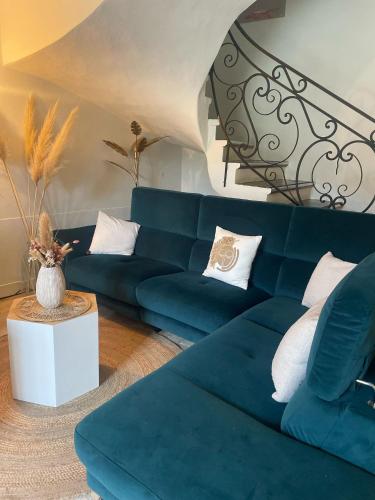 a living room with a blue couch and white pillows at La Passiflore in Vergèze