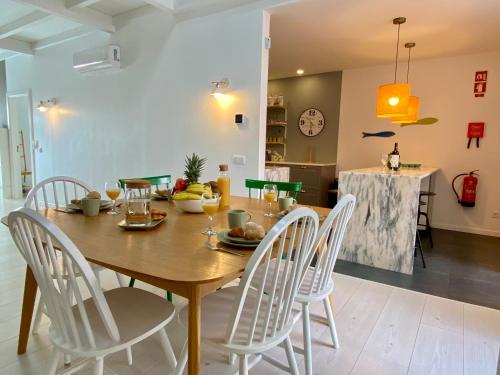 a dining room with a wooden table and white chairs at Portugal Secret by CORAL - Townhouse with small pool in Portimão