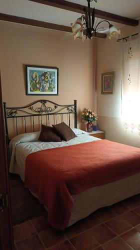 una camera da letto con un letto grande con una coperta rossa di Casa Maite a Riópar