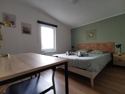 une chambre avec un lit, une table et une fenêtre dans l'établissement Le Saint Marc, à Quimper