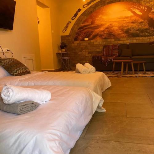 a hotel room with two beds with towels on them at סוויטת לורד הרמיטאז' בגולן in Bruchim Qela' Alon