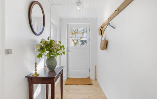 a hallway with a vase on a table and a mirror at Beautiful Apartment In Tranekær in Tranekær
