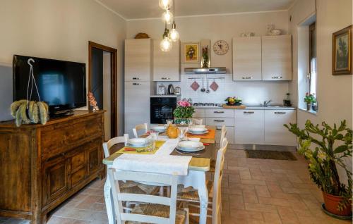 a kitchen with a table with chairs and a television at Pet Friendly Apartment in Chianciano Terme