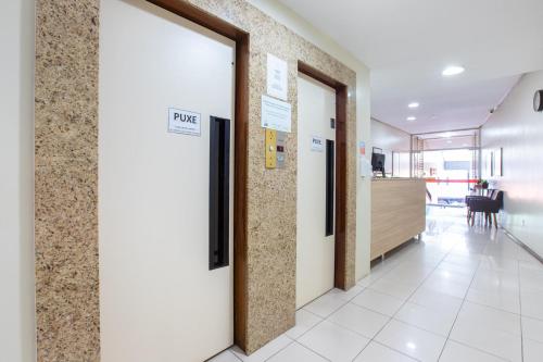 an office hallway with doors and a dining room at Hotel Express Confort in São Leopoldo