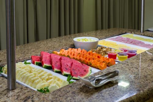 a buffet of different types of food on a counter at Brasília Tower Hotel by Castelo Itaipava in Brasilia